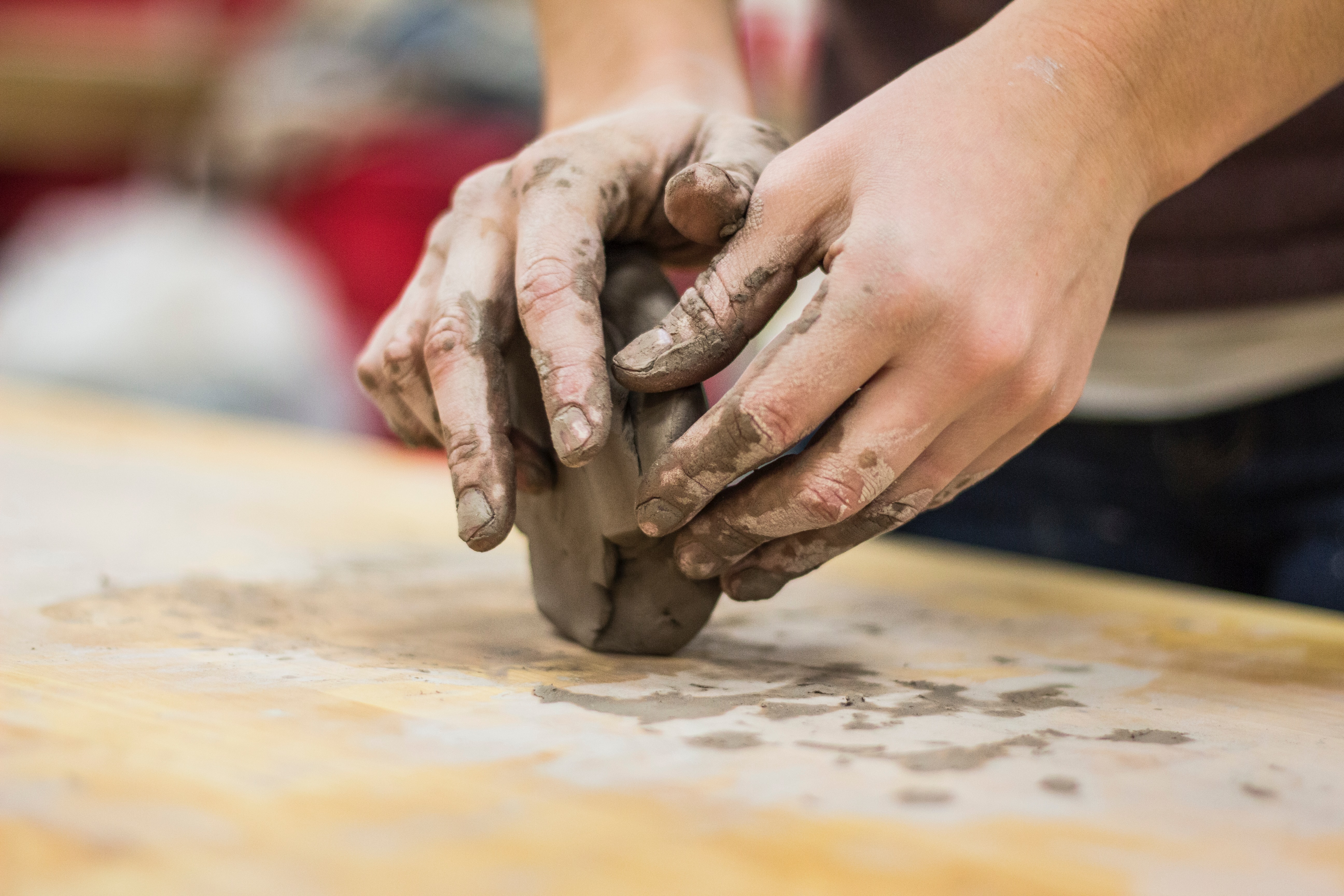 一个艺术家的手塑造湿粘土。