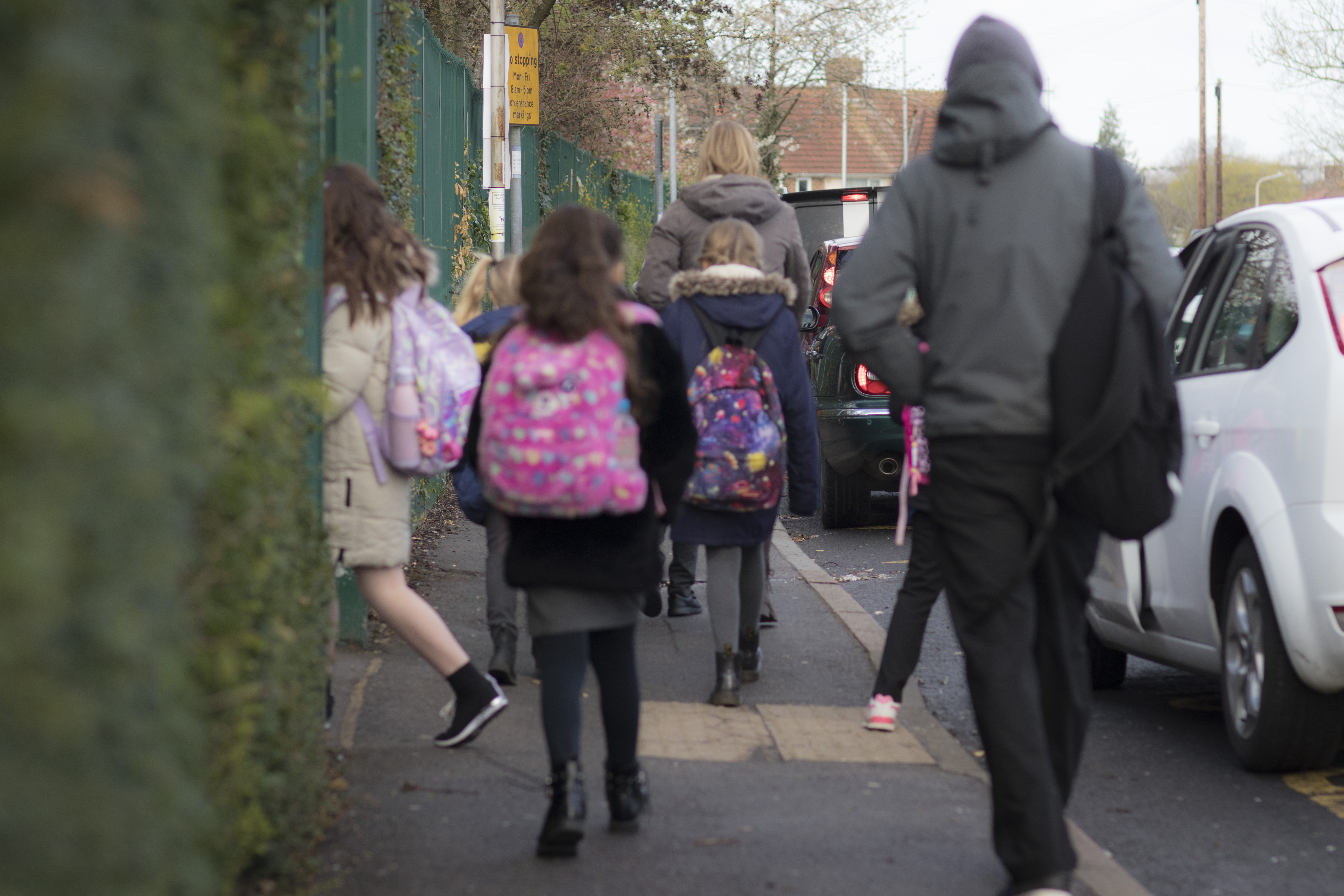 成人陪同一小群孩子步行上学。